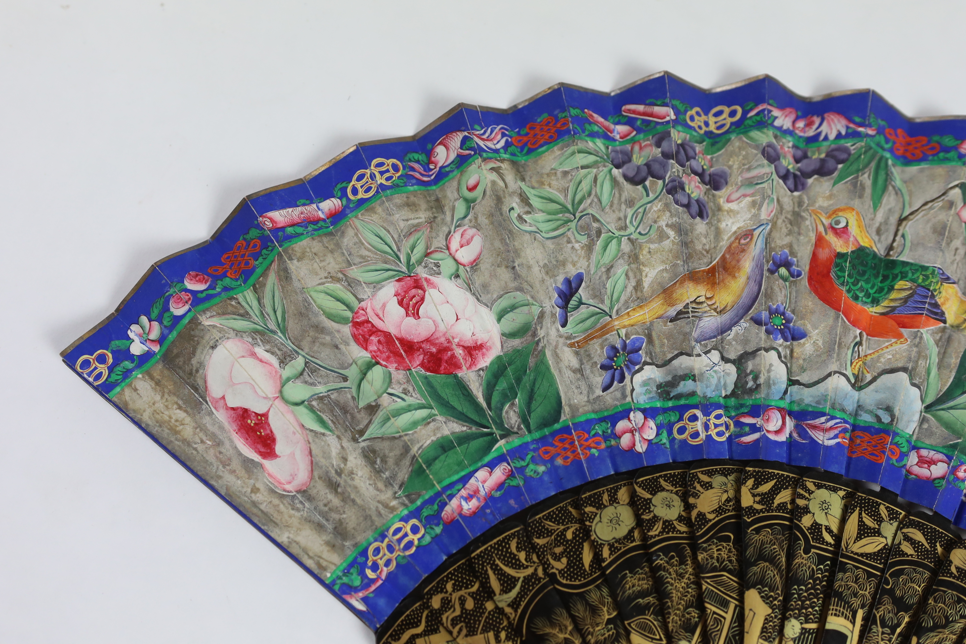 A 19th century Chinese ornately lacquered and hand painted figural leaf fan, the figures on the leaf having painted ivory faces, the back of the fan painted with exotic birds and flowers, CITES Submission reference TJUZX